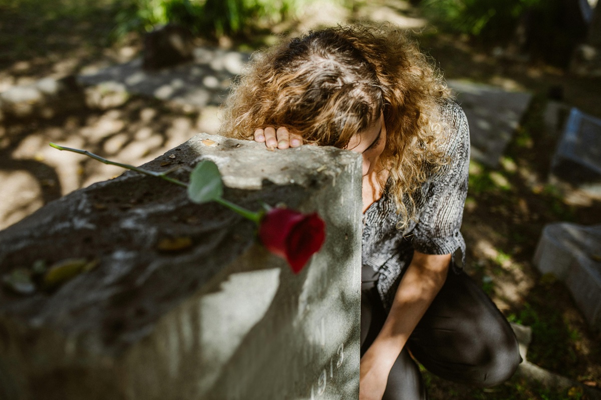 donna che piange davanti ad una tomba