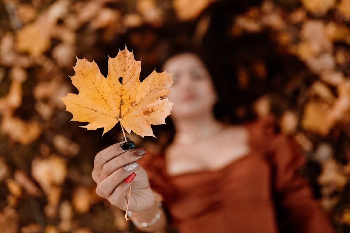 Una donna in contemplazione coglie il significato simbolico di una foglie che cade