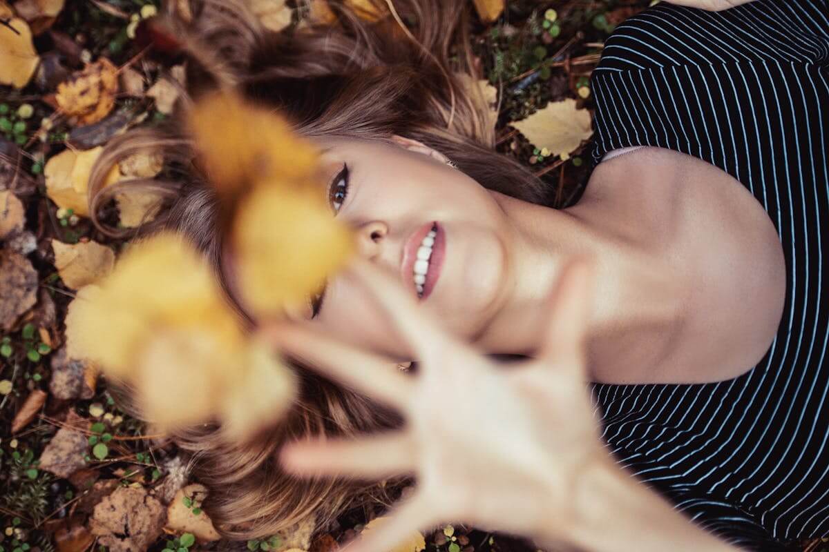 una donna osserva con attenzione le foglie che cadono