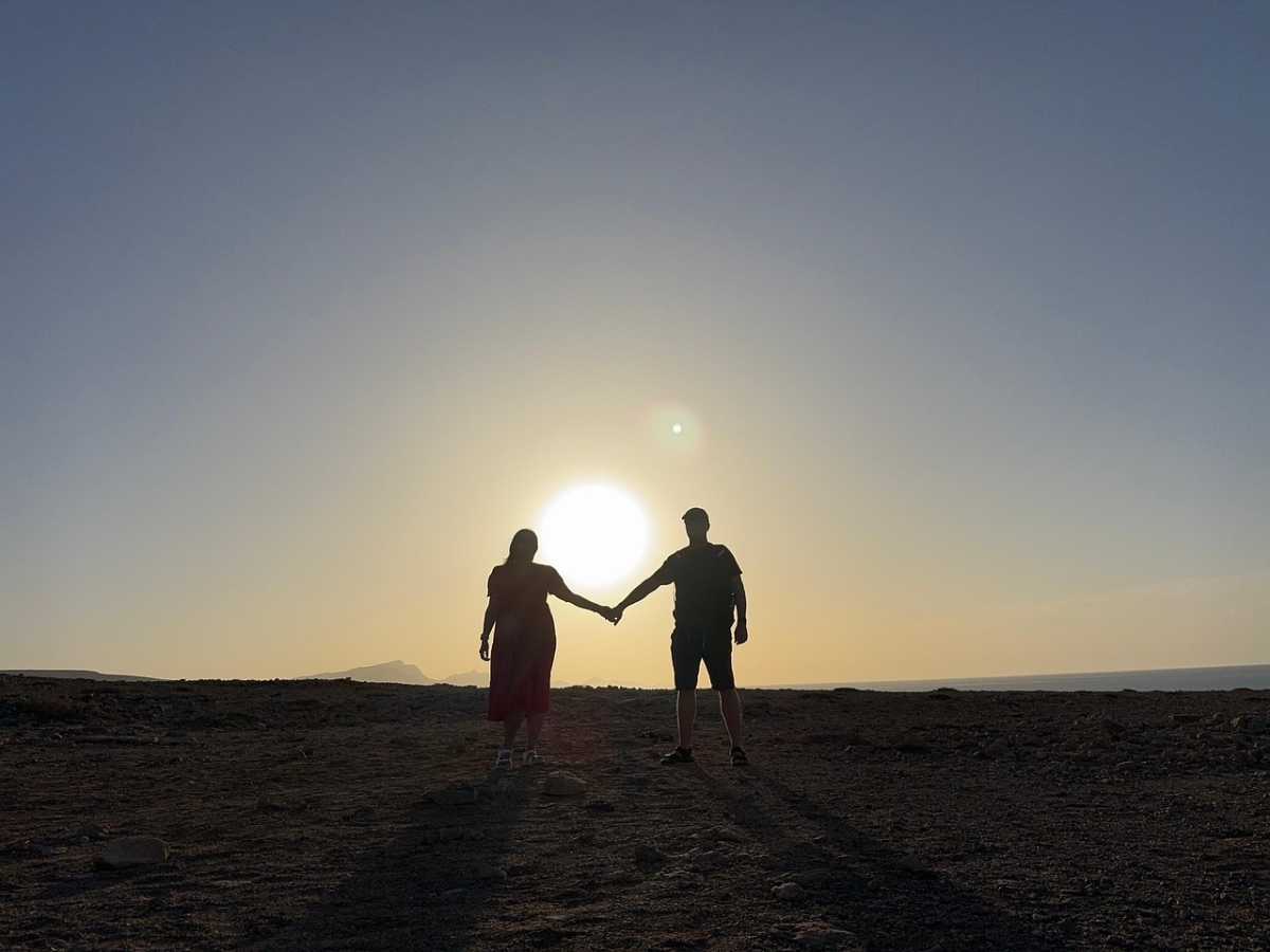 coppia in ombra che si tiene la mano