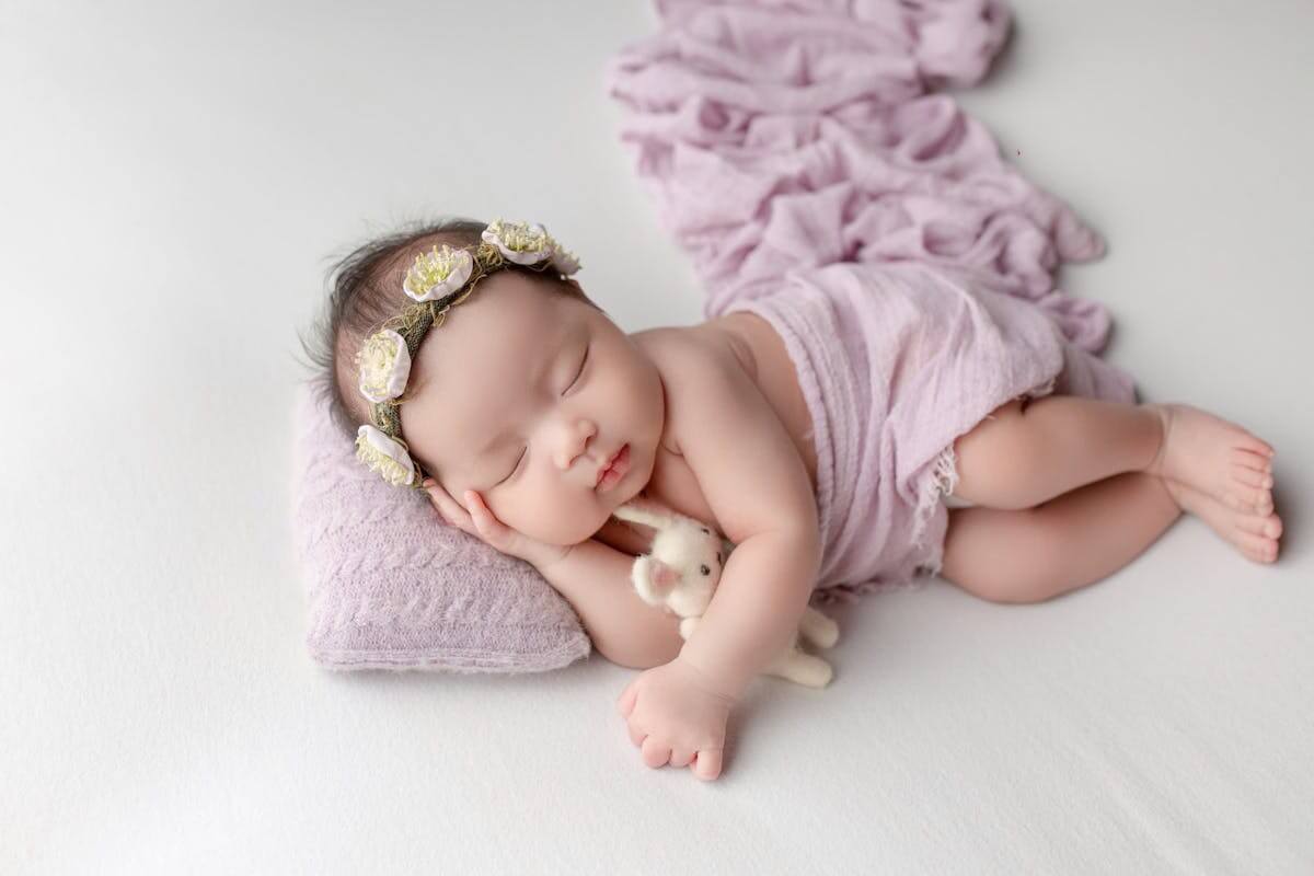 Bambina vestita con raffinatezza dorme con serenità, rappresenta l'eleganza del nome Valentina.