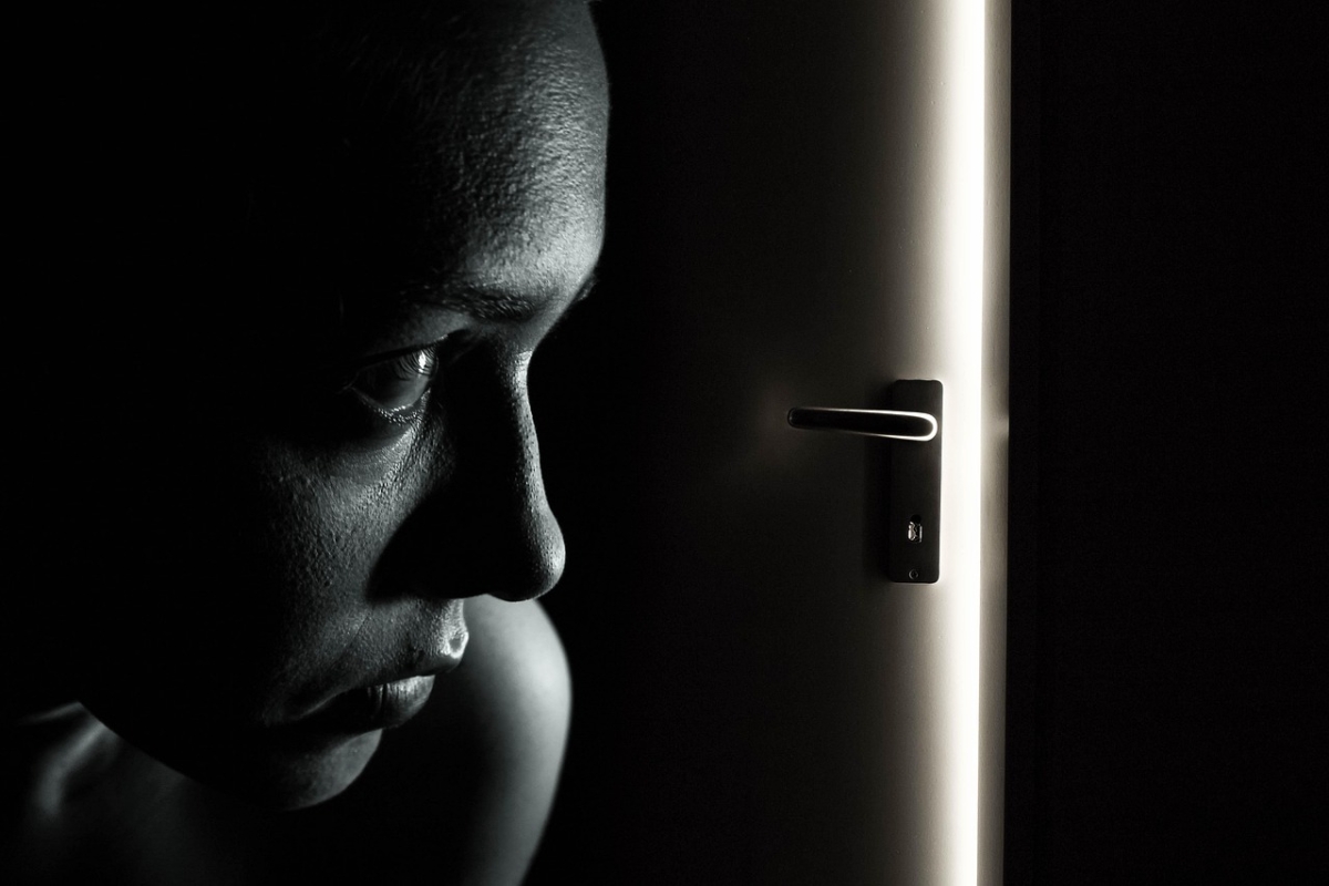 Donna che guarda impaurita dalla porta