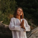 donna prega in natura, simboleggiando la spiritualità femminile