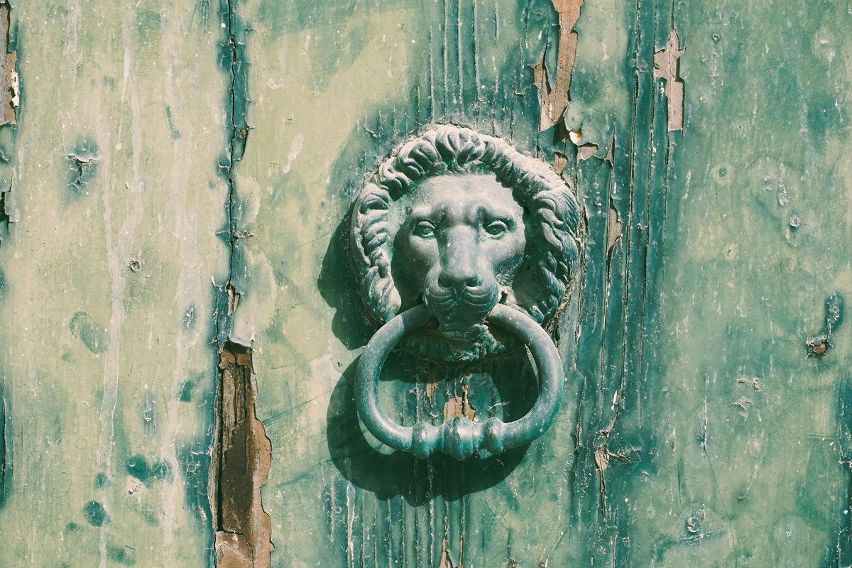 porta antica con maniglia a forma di leone