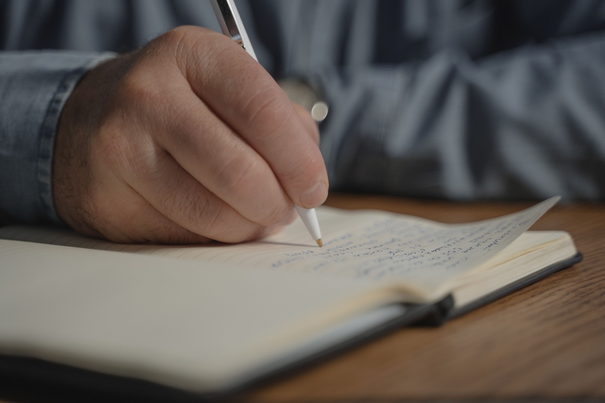 mano che scrive su un quaderno