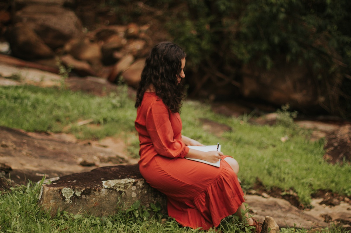 donna con un vestito rosso che scrive