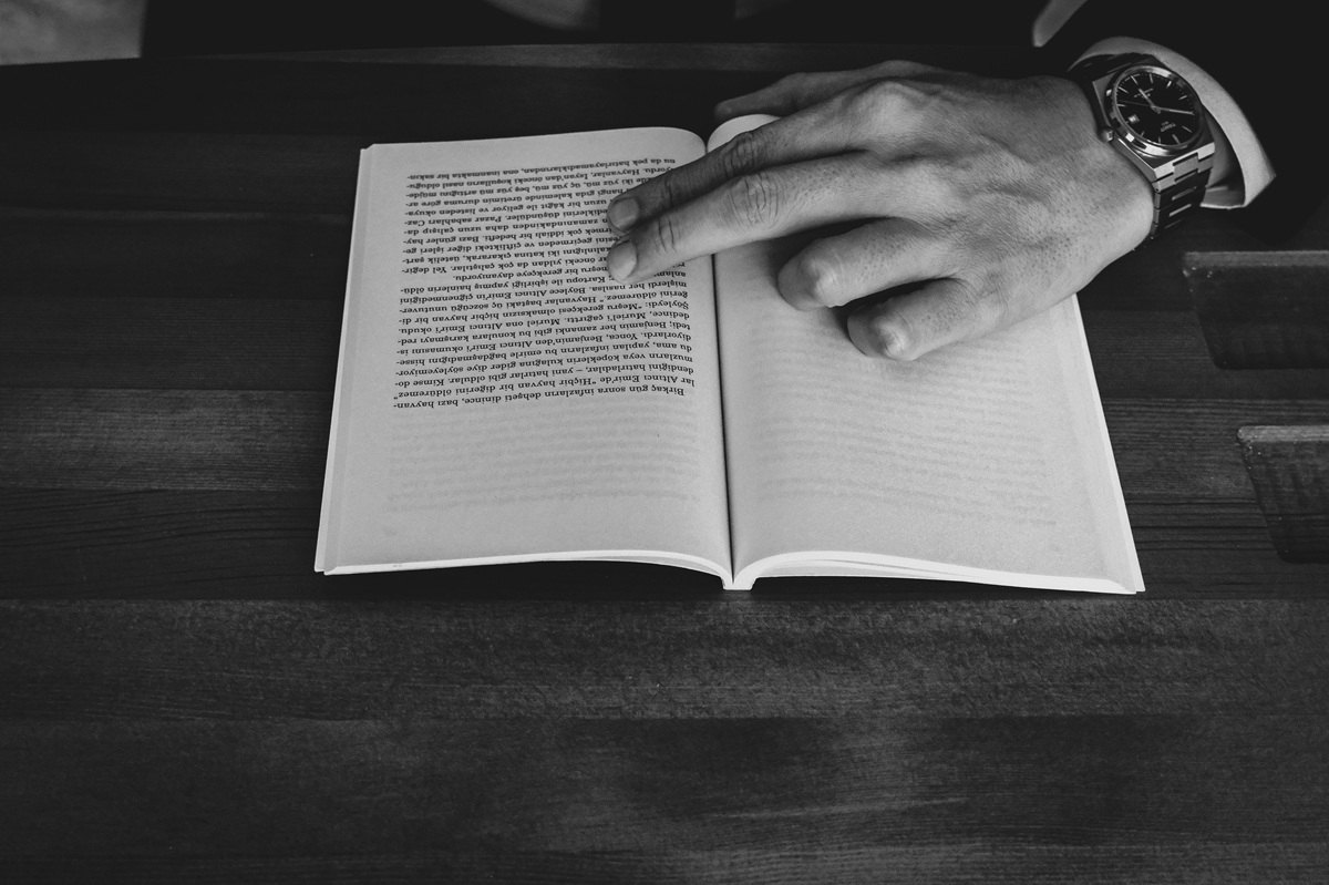 la mano di un uomo che sfoglia un libro