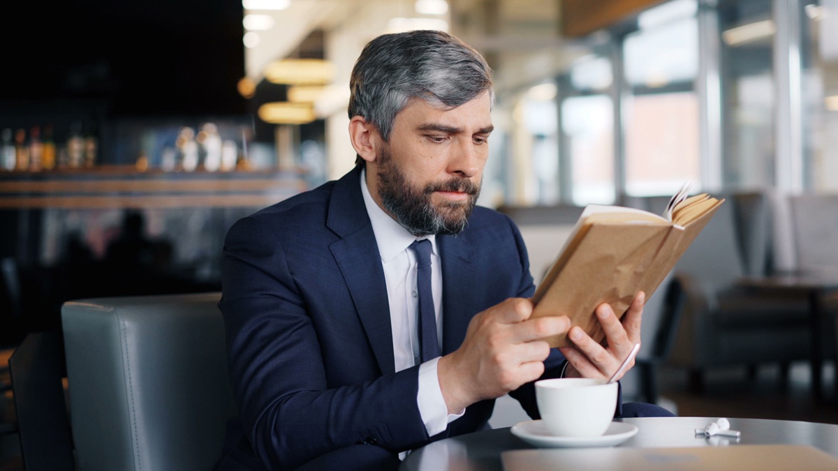 uomo d'affari che legge un libro